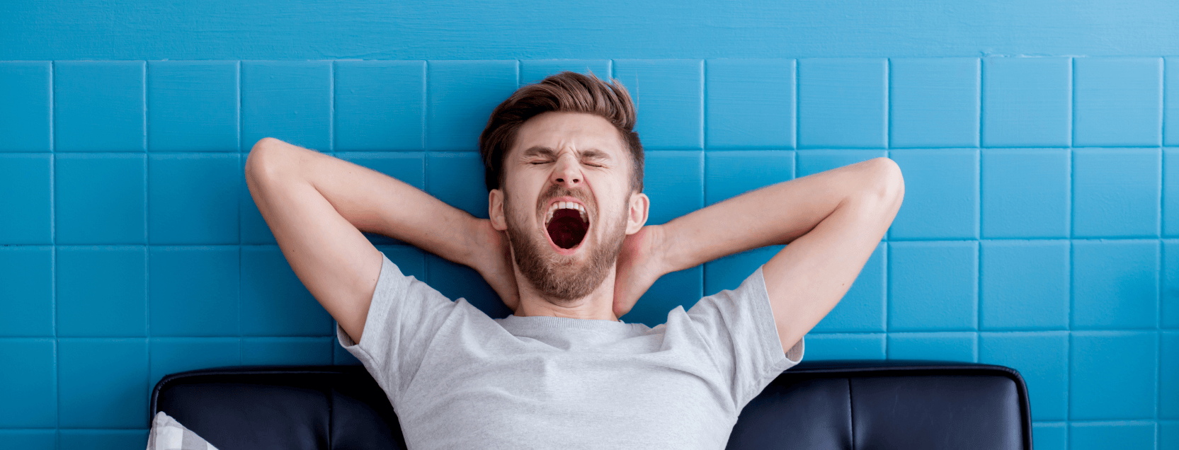 man yawning in bed